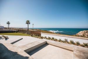a patio with a view of the ocean at MUTE Hostel Porto Covo in Porto Covo