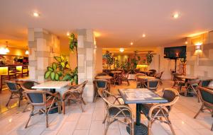 - un restaurant avec des tables et des chaises dans une salle dans l'établissement Carina Hotel, à Rhodes