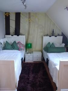 a bedroom with two beds with white sheets and green pillows at Ferienhaus Badetz in Badetz