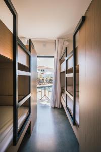 a room with bunk beds with a view of the ocean at MUTE Hostel Porto Covo in Porto Covo