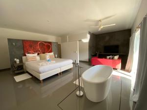 1 dormitorio con cama blanca y bañera. en CASA-22 Luxury Boutique Hotel, en Sosúa