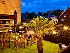 een patio met een tafel en stoelen en een palmboom bij Loft to go in Zedelgem