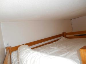 een kleine slaapkamer met een bed met witte lakens bij Appartement WIFI Monné centre Cauterets in Cauterets