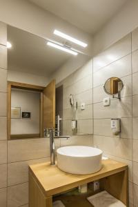 La salle de bains est pourvue d'un lavabo blanc et d'un miroir. dans l'établissement Boutique rooms Pri Rogovilcu, à Solčava