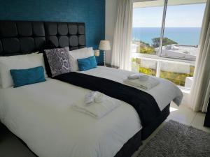 a bedroom with two beds and a large window at Diamond House Guesthouse in Cape Town