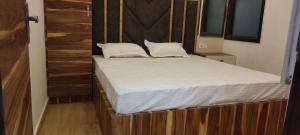 a bed with white sheets and pillows in a room at Hotel Golden Crown in Amritsar
