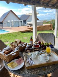 a table with a tray of breakfast food on it at Kanaloah Lodge & Cabins in Punta Del Diablo
