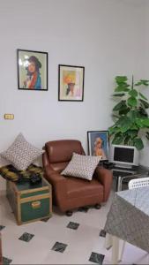 een woonkamer met een bruine stoel en een bureau bij La casa del mugnaio 2019 in Castronuovo di Sicilia