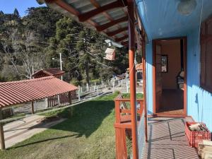 a porch of a blue house with a wooden door at Aconchegante Casa Serrana ao lado da Igreja Matriz in Urubici
