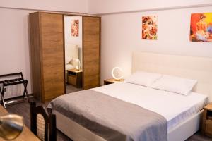 1 dormitorio con cama y espejo en Apartament ALESSIA, en Drobeta-Turnu Severin