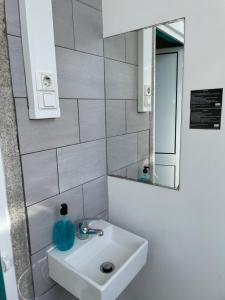 a bathroom with a sink and a mirror at By Doors Hostel in Porto
