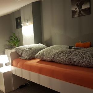 a bed with an orange mattress and pillows on it at Stadtnah an der Förde 104 in Flensburg