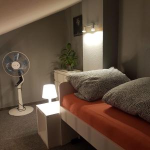 Schlafzimmer mit einem Bett, einem Ventilator und einer Lampe in der Unterkunft Stadtnah an der Förde 104 in Flensburg