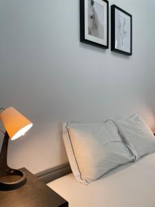 a bedroom with a bed and a lamp on the wall at By Doors Hostel in Porto