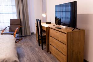 Schlafzimmer mit einem Schreibtisch und einem TV auf einer Kommode in der Unterkunft Apartament ALESSIA in Drobeta-Turnu Severin