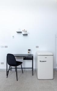 una scrivania con sedia e un frigorifero in camera di RIAMA AGRIRESORT a Napoli