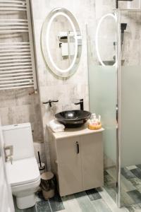 ein Badezimmer mit einem Waschbecken, einem WC und einem Spiegel in der Unterkunft Apartament ALESSIA in Drobeta-Turnu Severin
