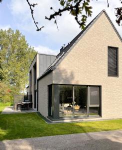 a brick house with large windows and a yard at Haus Meerling in Rerik