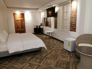 a bedroom with a white bed and a bathroom at Hostal & Spa Casa Real in Baños