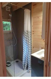 y baño con ducha, lavabo y cortina de ducha. en L'orée des bois , détente et calme . en Mésigny