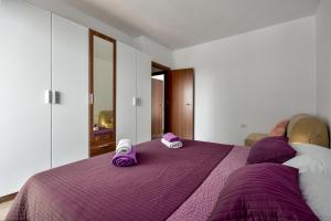 ein Schlafzimmer mit einem lila Bett und Hausschuhen darauf in der Unterkunft Apartman Grabar in Roč