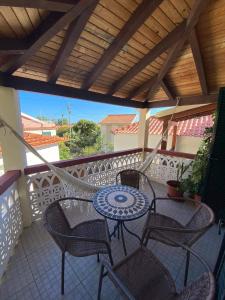 a patio with a table and chairs on a balcony at Cosy 2 bedroom home in the heart of Jardim do Mar in Jardim do Mar