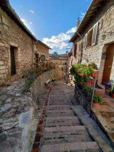 un vicolo in un centro storico con edifici e fiori di Le Casette di Franco & Anna ad Assisi