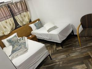 ein kleines Zimmer mit 2 Betten und einem Stuhl in der Unterkunft MERYLAND in Ramallah + 6 Fotos
