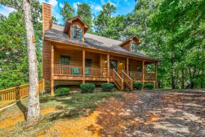 a log home with a large deck in the woods at Star Seasons Retreat in Ellijay