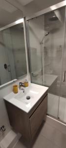 uma casa de banho com um lavatório e um chuveiro em Edificio Curitiba, Apartamento nuevo y céntrico 1B 1D em Temuco