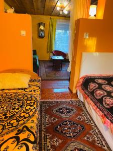 2 Betten in einem Zimmer mit orangefarbenen Wänden in der Unterkunft Noé Bárkája Vendégház in Nagyrákos
