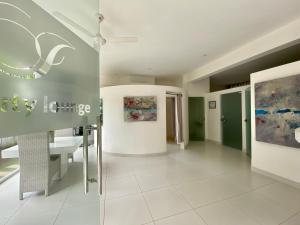 uma sala de estar com piso em azulejo branco e paredes verdes em CASA-22 Luxury Boutique Hotel em Sosúa