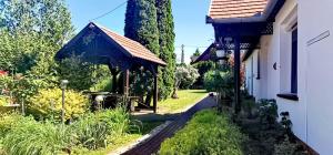 a garden with a gazebo next to a house at Noé Bárkája Vendégház in Nagyrákos