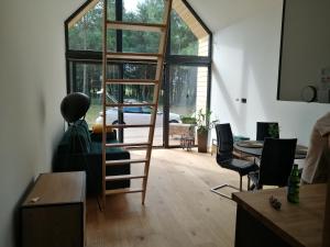 a living room with a ladder and a table and chairs at Domek Quatro Brzezinki in Brzezinki