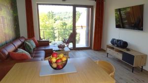 una sala de estar con una mesa con un bol de fruta. en Apartament DeLux 2, en Szklarska Poręba