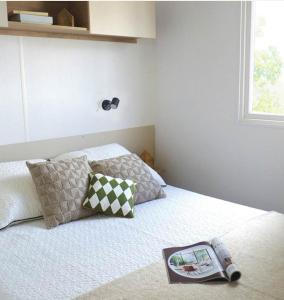 a bedroom with a bed with a book on it at Les mobilhomes helvétiques 4 étoiles Mar Estang Canet en Roussillon in Canet-en-Roussillon