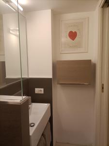 a bathroom with a white sink and a mirror at BE MY GUEST charme e relax in citta' alta in Bergamo