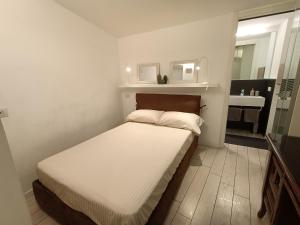a small bedroom with a bed and a mirror at BE MY GUEST charme e relax in citta' alta in Bergamo
