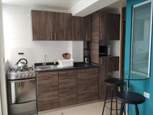a kitchen with wooden cabinets and a sink and a stove at La Casa de Justi in Huancayo