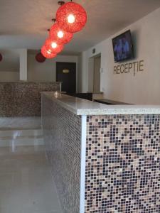 a lobby with a tile counter with red lights at Hotel Marie in Mamaia