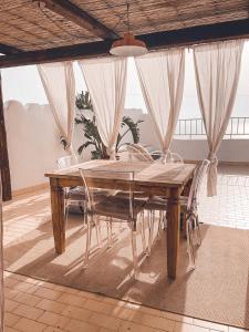una mesa de madera y sillas en una habitación en La Casa Sul Tramonto en Pantelleria