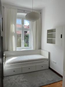 a white bench in a room with a window at Uroczy apartament 97m2 w samym centrum Wrocławia in Wrocław