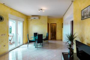 a living room with yellow walls and a table and chairs at Apartment Ben1 in Pula