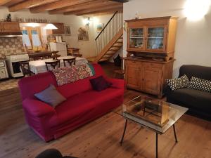 a living room with a red couch and a table at Chalet La Nos in Molina di Ledro