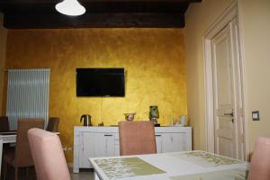 a dining room with a table and a television on a yellow wall at B & B Arcobaleno in Cosenza