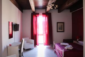 Habitación con ventana con cortina roja en B & B Arcobaleno, en Cosenza