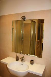 a bathroom with a sink and a large mirror at B & B Arcobaleno in Cosenza