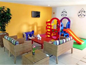 a living room with a table and a play set at Praia dos Carneiros Flat Hotel Apto Completo in Tamandaré +24 photos