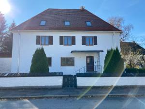 une maison blanche avec un toit marron dans l'établissement Stadtvilla Falkenstein, à Füssen