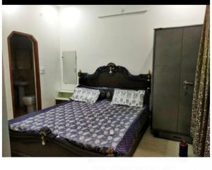 a bedroom with a wooden bed with two pillows at Shiv Gauri Home Stay in Rishīkesh +3 photos